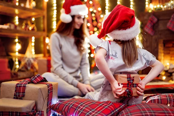 Glad mamma och hennes söta dotter flicka utbyter gåvor. Kärleksfull familj med presenterar i jul rum. — Stockfoto