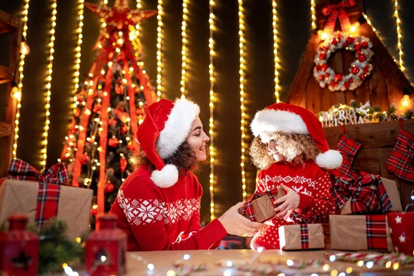 Vrolijke schattig klein meisje en haar oudere zus uitwisselen van geschenken. — Stockfoto