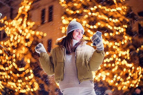 Een mooie jonge vrouw of meisje doet selfie of met behulp van telefoon buitenshuis — Stockfoto