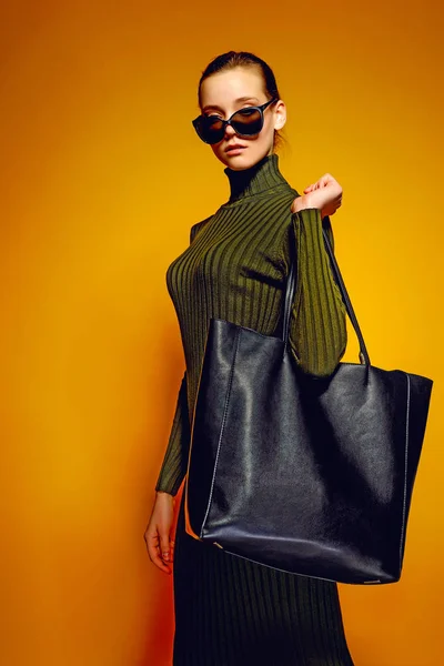 Svart fredag försäljning koncept. Shopping kvinna anläggning svart läderväska isolerad på gul bakgrund — Stockfoto