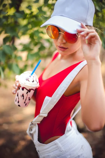 Retrato al aire libre de chica de moda bastante elegante divirtiéndose bebiendo batido . —  Fotos de Stock