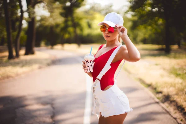 Retrato ao ar livre de menina de moda muito elegante se divertindo bebendo milkshake . — Fotografia de Stock