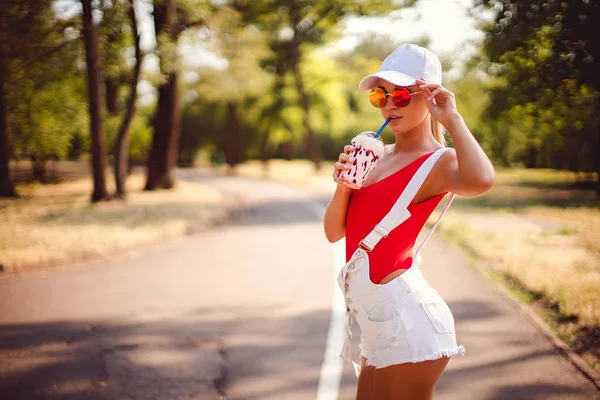 Retrato ao ar livre de menina de moda muito elegante se divertindo bebendo milkshake . — Fotografia de Stock