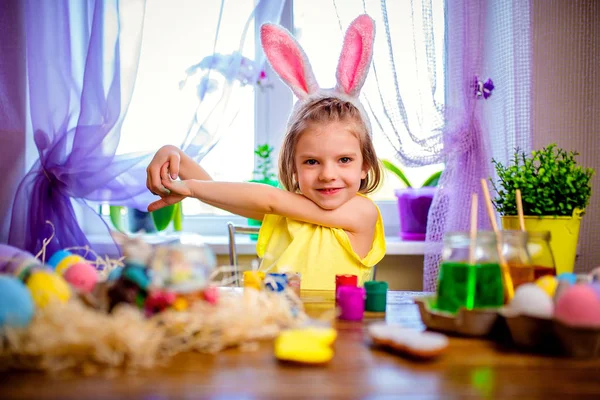 Happy easter dziewczyna w uszy królika, malowanie pisanek, małe dziecko w domu. Święto wiosny — Zdjęcie stockowe