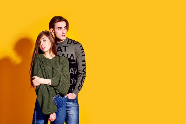 Coppia posa in jeans tipo stile moda commerciale su parete gialla — Foto Stock