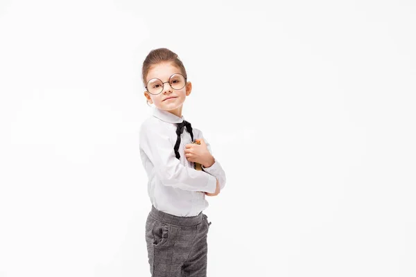 Mooie meisje in wit overhemd en een grijze broek permanent in de buurt van witte muur en poseren als model — Stockfoto