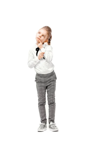 Красива маленька дівчинка в білій сорочці і сірі штани, що стоять біля білої стіни і позують як модель — стокове фото