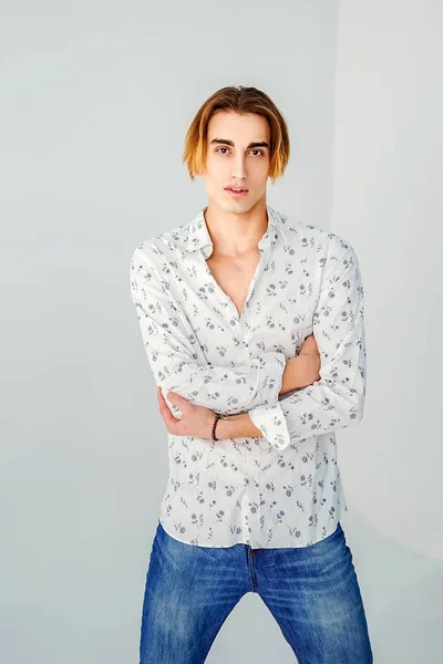 Модний портрет молодого чоловіка в білій сорочці над сірою стіною — стокове фото