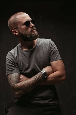 Güneş gözlüğü ve gri gömlek uzak tarafına bakarak uzun de kesilmiş sakallı yakışıklı balded adam portresi