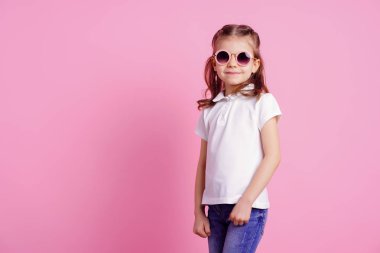 Rahat 7 yaşında erkek, pembe arka plan izole pembe yuvarlak güneş gözlüğü