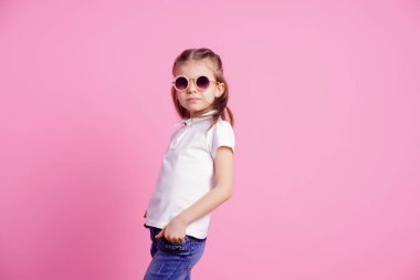 Rahat 7 yaşında erkek, pembe arka plan izole pembe yuvarlak güneş gözlüğü