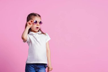 Rahat 7 yaşında erkek, pembe arka plan izole pembe yuvarlak güneş gözlüğü