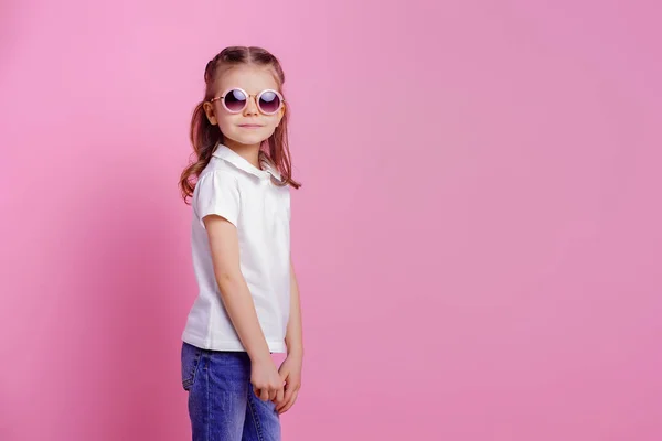 Casual 7 ετών γυναίκα σε ροζ στρογγυλά γυαλιά ηλίου που απομονώνονται σε ροζ φόντο — Φωτογραφία Αρχείου