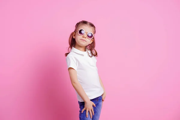 Casual 7 y.o. female in pink round sunglasses isolated on pink background — Stock Photo, Image