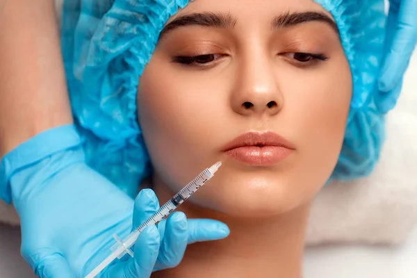 Der Arzt Kosmetologe macht die Verjüngende Gesichtsinjektion Verfahren zur Straffung und Glättung von Falten auf der Gesichtshaut einer Frau in einem Schönheitssalon. Kosmetologie Hautpflege — Stockfoto