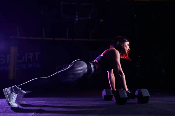 Atractiva en forma mujer de mediana edad está haciendo ejercicio tablón mientras hace ejercicio en el gimnasio — Foto de Stock