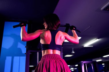 Atletik kadın için sırt, egzersiz yaparak makinasıyla, spor salonunda - arkadan görünüm