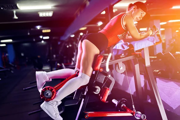 Γυμναστήριο γυναίκα κάνει κάνει κάνει ασκήσεις για την προπόνηση με τα πόδια των μυών στο γυμναστήριο — Φωτογραφία Αρχείου