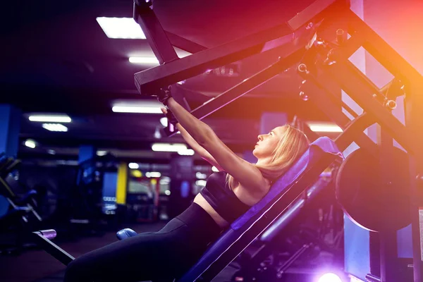 Atraktivní a vhodná žena středního věku cvičeních na svalech na simulátoru. Automat na tělocvičnu — Stock fotografie