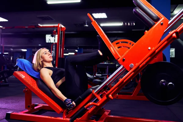 Γυμναστήριο γυναίκα κάνει κάνει κάνει ασκήσεις για την προπόνηση με τα πόδια των μυών στο γυμναστήριο — Φωτογραφία Αρχείου