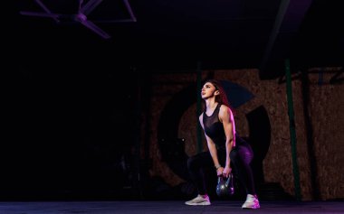 Çekici fit bayan sporcu spor salonunda salıncak sallıyor.