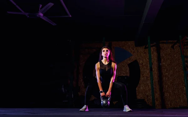 Atractiva atleta mujer en forma realizando un columpio hervidor-campana en el gimnasio — Foto de Stock