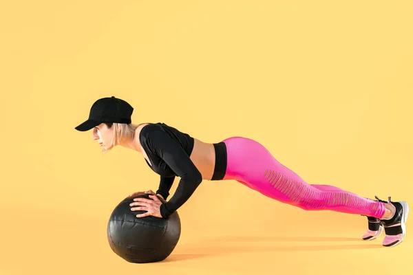 Vrouw in fitness kleding training met een medicijnbal. Vrouwelijke atleet doet buiktraining met behulp van een medicijnbal — Stockfoto
