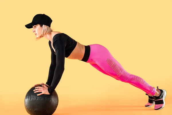 Vrouw in fitness kleding training met een medicijnbal. Vrouwelijke atleet doet buiktraining met behulp van een medicijnbal — Stockfoto