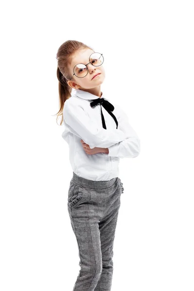 Όμορφο μικρό κορίτσι με λευκό πουκάμισο και γκρι παντελόνια στέκεται νέα — Φωτογραφία Αρχείου