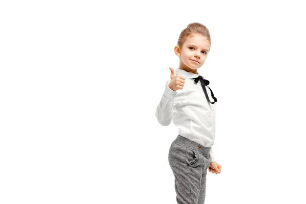 Красива маленька дівчинка в білій сорочці і сірі штани, що стоять — стокове фото