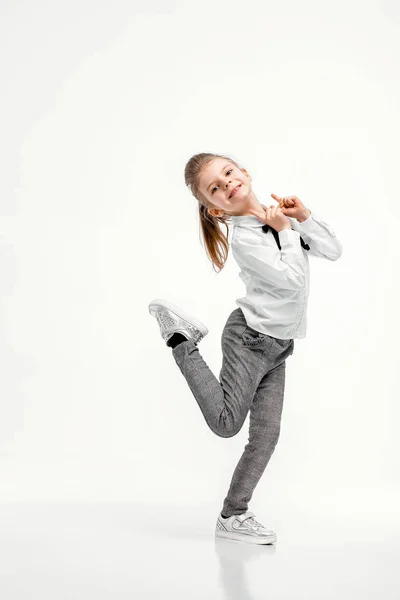 Bella bambina in camicia bianca e pantaloni grigi in piedi nea — Foto Stock