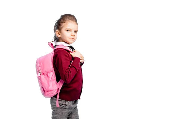 Niño con mochila. Chica en camisa blanca y pantalones grises, mantenga una — Foto de Stock