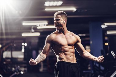 Beyaz yakışıklı fitness modeli spor salonunda poz. Diyet adam kasları esneme ve altı paketi abs