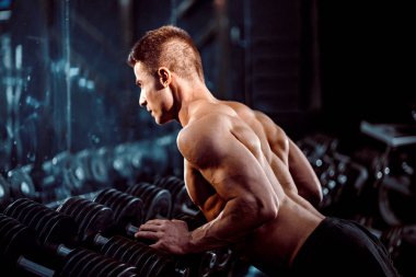 Spor. Yakışıklı adam fitness salonunda bir eliyle push up egzersiz yapıyor