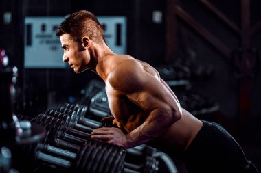 Spor. Yakışıklı adam fitness salonunda bir eliyle push up egzersiz yapıyor