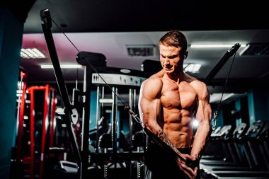 Tel kablo makinesi göğüs sinek egzersizleri yapıyor spor salonunda çalışan Kas vücut oluşturucu