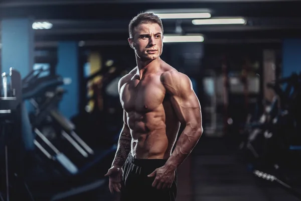 Kaukaski przystojny model fitness stwarzające w siłowni. Człowiek na diecie mięśni zginanie i sześciopak ABS — Zdjęcie stockowe