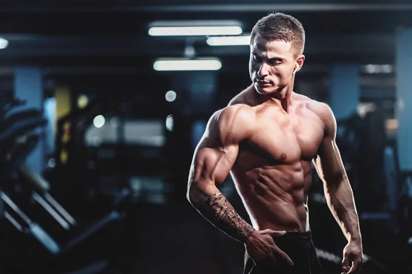 Beyaz yakışıklı fitness modeli spor salonunda poz. Diyet adam kasları esneme ve altı paketi abs — Stok fotoğraf