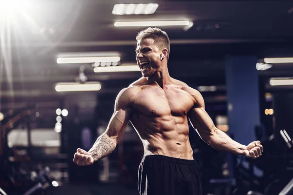 Modèle de fitness beau caucasien posant dans la salle de gym. Homme sur le régime flexion des muscles et six pack abs — Photo