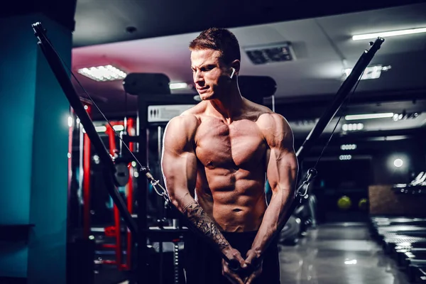 Gespierde lichaam bouwer trainen in de sportschool doen borst vliegen oefeningen op de draadkabel machine — Stockfoto