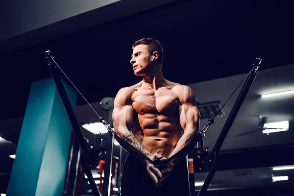 Tel kablo makinesi göğüs sinek egzersizleri yapıyor spor salonunda çalışan Kas vücut oluşturucu — Stok fotoğraf