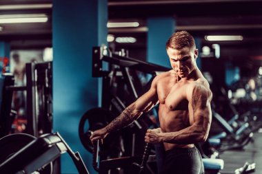 Arka üstünde makine için ağır egzersiz yaparak güçlü vücut geliştirmeci