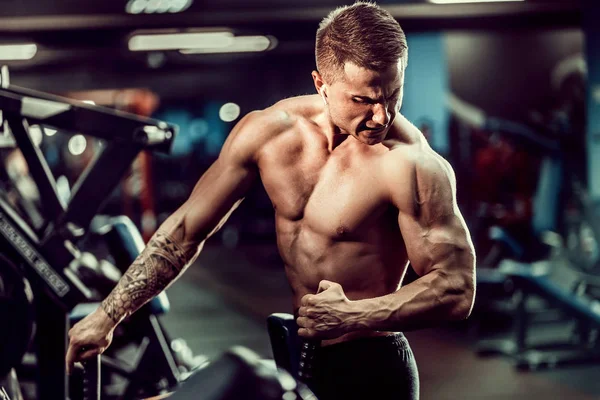 Arka üstünde makine için ağır egzersiz yaparak güçlü vücut geliştirmeci — Stok fotoğraf