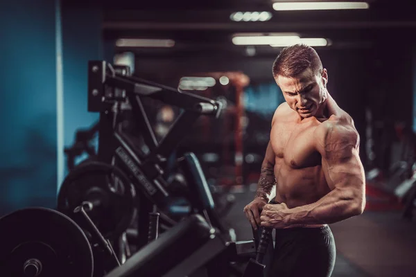 Starker Bodybuilder, der schwere Kraftübungen für den Rücken auf dem Gerät macht — Stockfoto