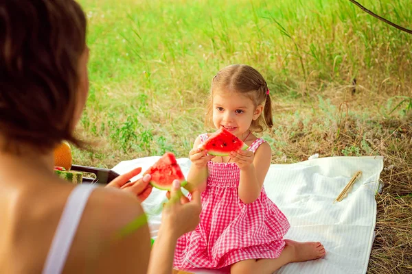 Karpuz, sağlıklı meyve çerez, sıcak bir yaz gününde güneşli bir çayırda oynayan sevimli yürümeye başlayan çocuk yiyen inanılmaz güzel küçük kız komik portre — Stok fotoğraf