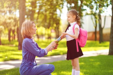 Okuldaki ilk gün. anne birinci sınıfta küçük bir çocuk okul kız yol açar. Sırt çantası arkada olan kadın ve kız. Derslerin başlangıcı. Fal'ın ilk günü