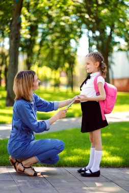 Okuldaki ilk gün. anne birinci sınıfta küçük bir çocuk okul kız yol açar. Sırt çantası arkada olan kadın ve kız. Derslerin başlangıcı. Fal'ın ilk günü