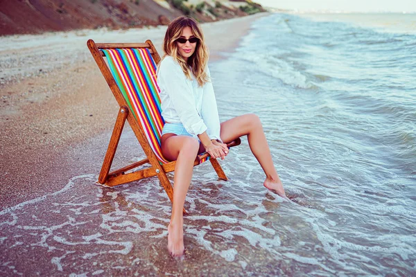 Mulher bonita relaxando em uma praia de espreguiçadeira. conceito férias de verão — Fotografia de Stock