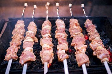 Metal şişte çiğ kebap pişirilir. Barbeküde pişirilen kavrulmuş et. Geleneksel doğu yemeği, şiş kebap. Kömür ve alev, piknik, sokak gıda Izgara