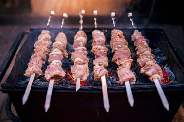 Metal şişte çiğ kebap pişirilir. Barbeküde pişirilen kavrulmuş et. Geleneksel doğu yemeği, şiş kebap. Kömür ve alev, piknik, sokak gıda Izgara